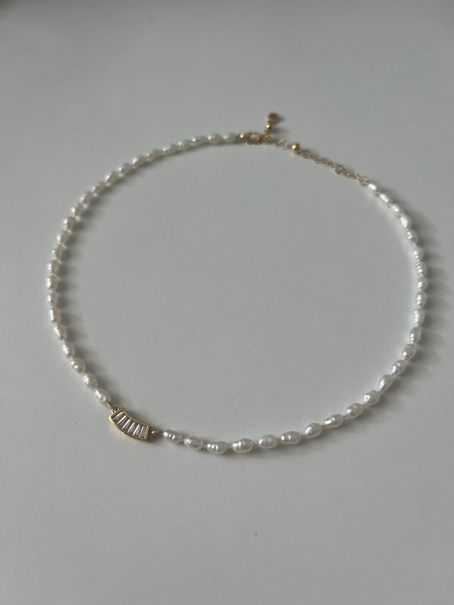 Girocollo di perle naturali annodati con pendente punto luce di zirconi. Perfetto per un look estivo. 