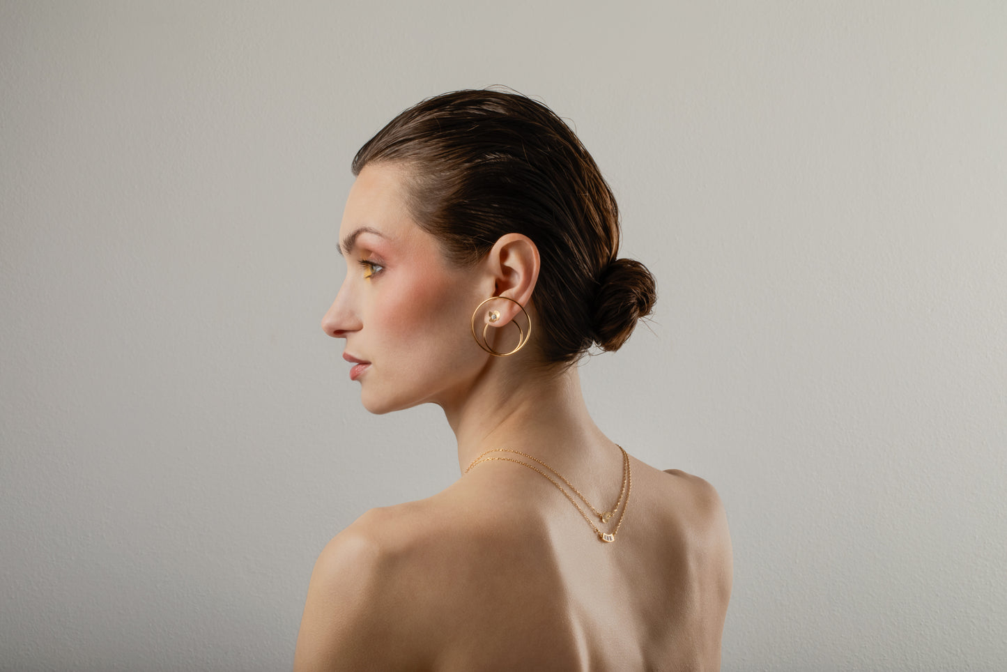 Il profilo dell’orecchino Ninfea con piccoli zirconi illumina il charm DoppiaOrbita di MyOhJewelry, in argento placcato oro.