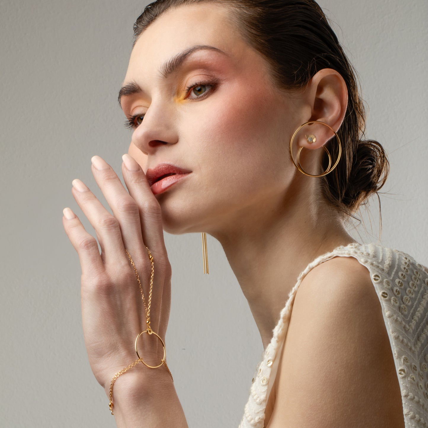 Il doppio cerchio del charm DoppiaOrbita della linea MyohJewelry si abbina al bracciale baciamano Orbita, in argento placcato oro.